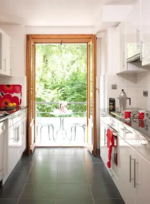 a kitchen with a large door leading to a balcony at Aran Apartment - Chamonix in Chamonix-Mont-Blanc