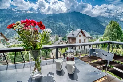 a vase of flowers on a table on a balcony at Aran Apartment - Chamonix in Chamonix-Mont-Blanc