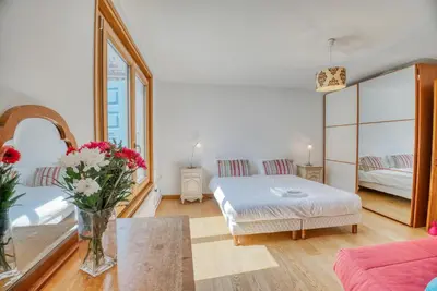 a living room with a bed and a table with flowers at Aran Apartment - Chamonix in Chamonix-Mont-Blanc