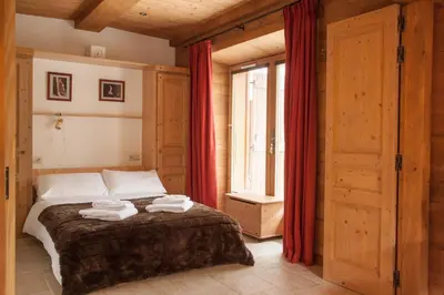 a bedroom with a bed with red curtains at Petite Savoyarde - Chamonix in Chamonix-Mont-Blanc