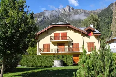 a house with a balcony and mountains in the background at Petite Savoyarde - Chamonix in Chamonix-Mont-Blanc