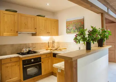a kitchen with wooden cabinets and a stove top oven at Petite Savoyarde - Chamonix in Chamonix-Mont-Blanc