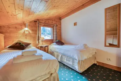 two beds in a room with wooden walls at Clos 3 - Chamonix in Chamonix-Mont-Blanc