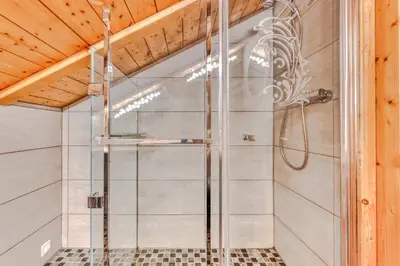 a shower with a glass door in a bathroom at Morgane Apartment in Chamonix-Mont-Blanc