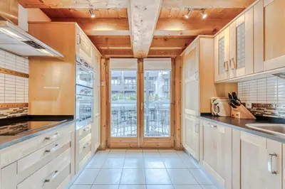 a kitchen with wooden ceilings and a large window at Morgane Apartment in Chamonix-Mont-Blanc