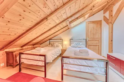 two beds in a attic bedroom with wooden ceilings at Morgane Apartment in Chamonix-Mont-Blanc