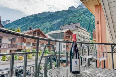 a bottle of wine sitting on a table on a balcony at Morgane Apartment in Chamonix-Mont-Blanc