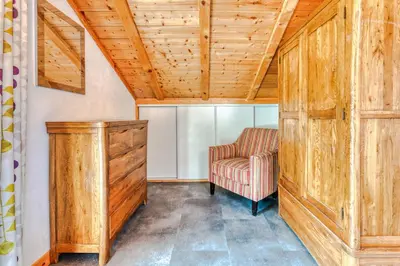 a room with a chair and a wooden cabinet at Morgane Apartment in Chamonix-Mont-Blanc
