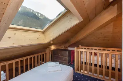 a loft bedroom with a bed and a window at Polaris - Chamonix in Chamonix-Mont-Blanc
