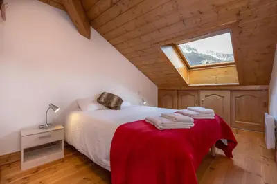 a bedroom with a bed with a red blanket and a window at Polaris - Chamonix in Chamonix-Mont-Blanc