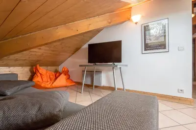 a living room with a couch and a television at Polaris - Chamonix in Chamonix-Mont-Blanc