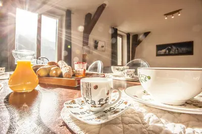 a table with cups and plates and bread on it at Vieux Palais - Chamonix in Chamonix-Mont-Blanc