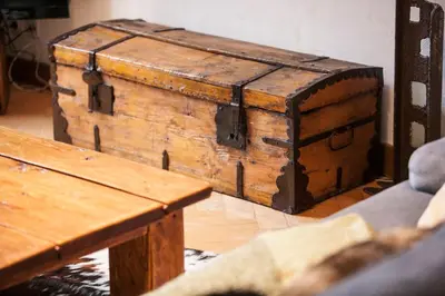 an old wooden chest sitting next to a wooden table at Vieux Palais - Chamonix in Chamonix-Mont-Blanc