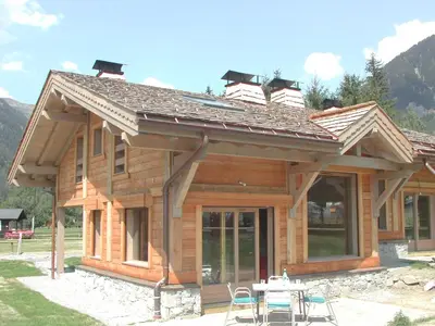 a log cabin with a table and chairs in front of it at Chalet Bois - Chamonix in Chamonix-Mont-Blanc