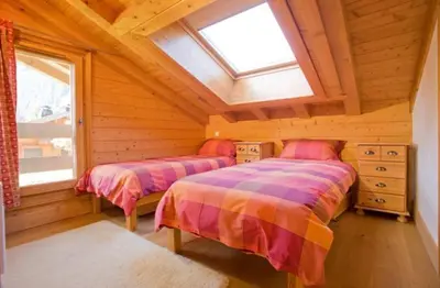 a bedroom with two beds in a log cabin at Chalet Bois - Chamonix in Chamonix-Mont-Blanc