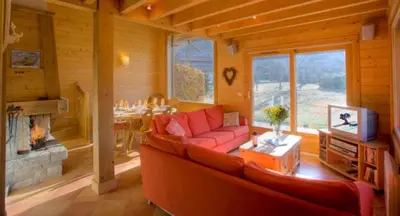 a living room with a red couch and a fireplace at Chalet Bois - Chamonix in Chamonix-Mont-Blanc