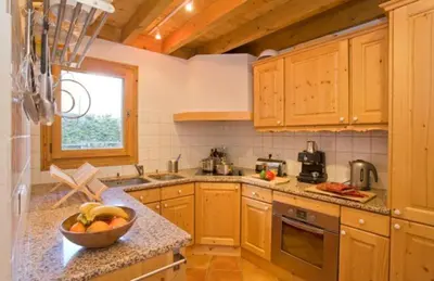 a kitchen with wooden cabinets and a bowl of fruit on a counter at Chalet Bois - Chamonix in Chamonix-Mont-Blanc