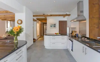 a kitchen with white cabinets and a vase of flowers at Chalet des Lacs - Chamonix in Chamonix-Mont-Blanc