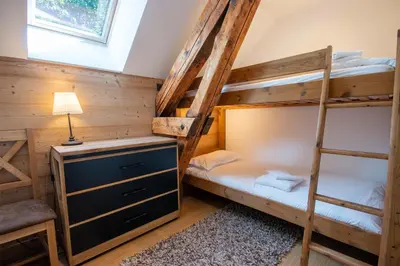 a bedroom with two bunk beds and a desk at Chalet des Lacs - Chamonix in Chamonix-Mont-Blanc