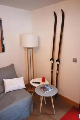 a living room with a couch and skis on the wall at Appartement 25m2 à Saint-Gervais les bains in Saint-Gervais-les-Bains