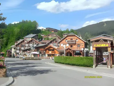 a street in a mountain town with wooden buildings at Studio accueillant à Les Carroz, 27 m², vue montagne in Les Carroz d'Araches