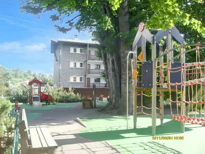 a playground in front of a large tree at Studio accueillant à Les Carroz, 27 m², vue montagne in Les Carroz d'Araches