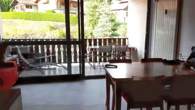 a room with a table and chairs on a balcony at Studio accueillant à Les Carroz, 27 m², vue montagne in Les Carroz d'Araches