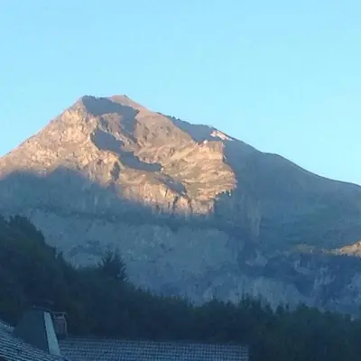 a snow covered mountain in the distance with a house at Appartement cosy aux Carroz, 40 m², vue sur la montagne in Les Carroz d'Araches
