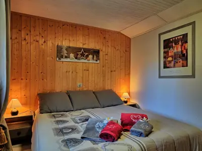 a bedroom with a bed with red pillows on it at Appartement cosy aux Carroz, 40 m², vue sur la montagne in Les Carroz d'Araches