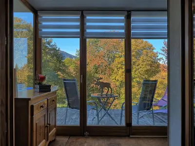 a kitchen with sliding glass doors with a dog on a table at Appartement cosy aux Carroz, 40 m², vue sur la montagne in Les Carroz d'Araches