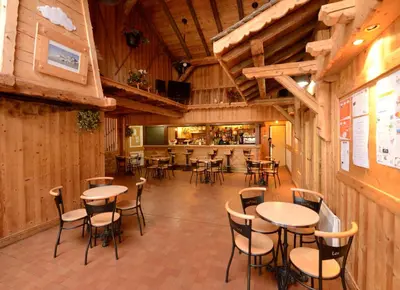 a restaurant with tables and chairs and a bar at Village De Vacances Les Flocons Verts in Les Carroz d'Araches