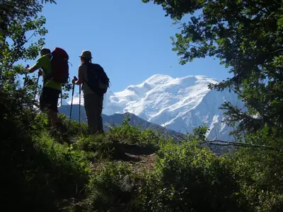 two people standing on a hill looking at a snow covered mountain at Village De Vacances Les Flocons Verts in Les Carroz d'Araches