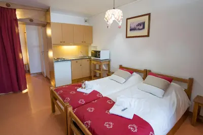 a bedroom with two beds with a cat laying on the bed at Village De Vacances Les Flocons Verts in Les Carroz d'Araches