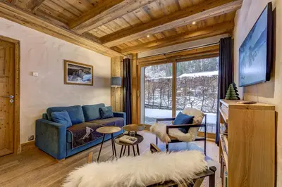 a living room with a blue couch and a tv at Blaitiere 2 Apartment in Chamonix-Mont-Blanc