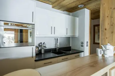 a kitchen with white cabinets and a wooden counter top at Blaitiere 2 Apartment in Chamonix-Mont-Blanc