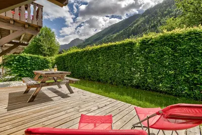 a wooden deck with a picnic table and chairs at Blaitiere 2 Apartment in Chamonix-Mont-Blanc