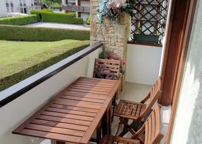 a wooden table and chairs on a balcony at Samoëns Apartment 2 bedroom 50m2 modern and well equipt in Samoëns