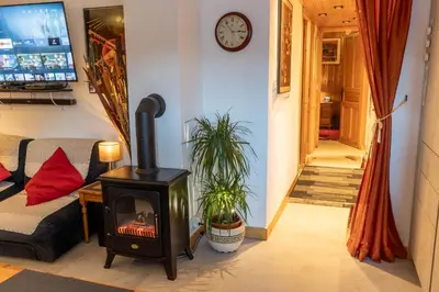 a living room with a wood stove and a staircase at Samoëns Apartment 2 bedroom 50m2 modern and well equipt in Samoëns