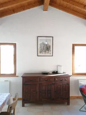 a room with a wooden cabinet and two windows at Chalet Erminea in Chamonix-Mont-Blanc