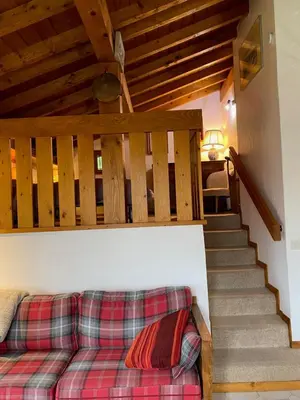 a living room with a couch and stairs at Chalet Erminea in Chamonix-Mont-Blanc