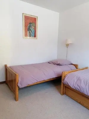 two beds in a room with a picture on the wall at Chalet Erminea in Chamonix-Mont-Blanc