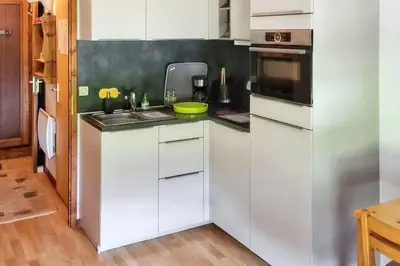 a kitchen with white cabinets and a sink at Charmant studio avec vue sur le Mont Blanc - 22 m² - Cordon in Cordon