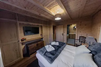a room with a bed and a tv and a couch at Chalet Krystal in Arâches-la-Frasse