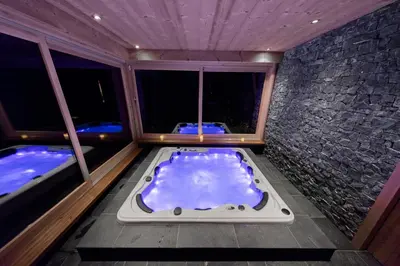 a bath tub in a room with two jacuzzles at Chalet Krystal in Arâches-la-Frasse