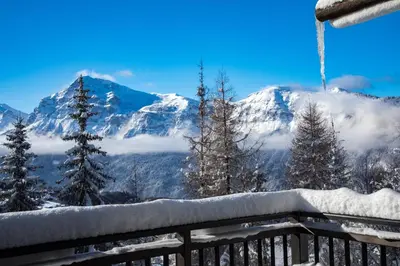 a view of a snow covered mountain from a balcony at Chalet Krystal in Arâches-la-Frasse