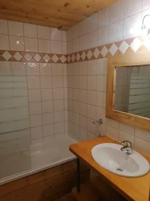 a bathroom with a sink and a tub and a mirror at Résidence Chalet des Granges in Samoëns