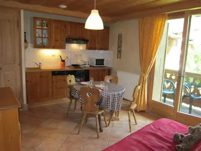 a kitchen and dining room with a table and chairs at Résidence Chalet des Granges in Samoëns