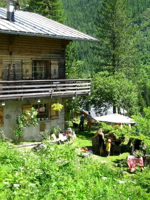 a group of people sitting in front of a house at The Guest House in Vallorcine