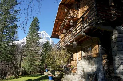 a building with a snow covered mountain in the background at The Guest House in Vallorcine