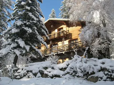 a log cabin in the woods in the snow at The Guest House in Vallorcine